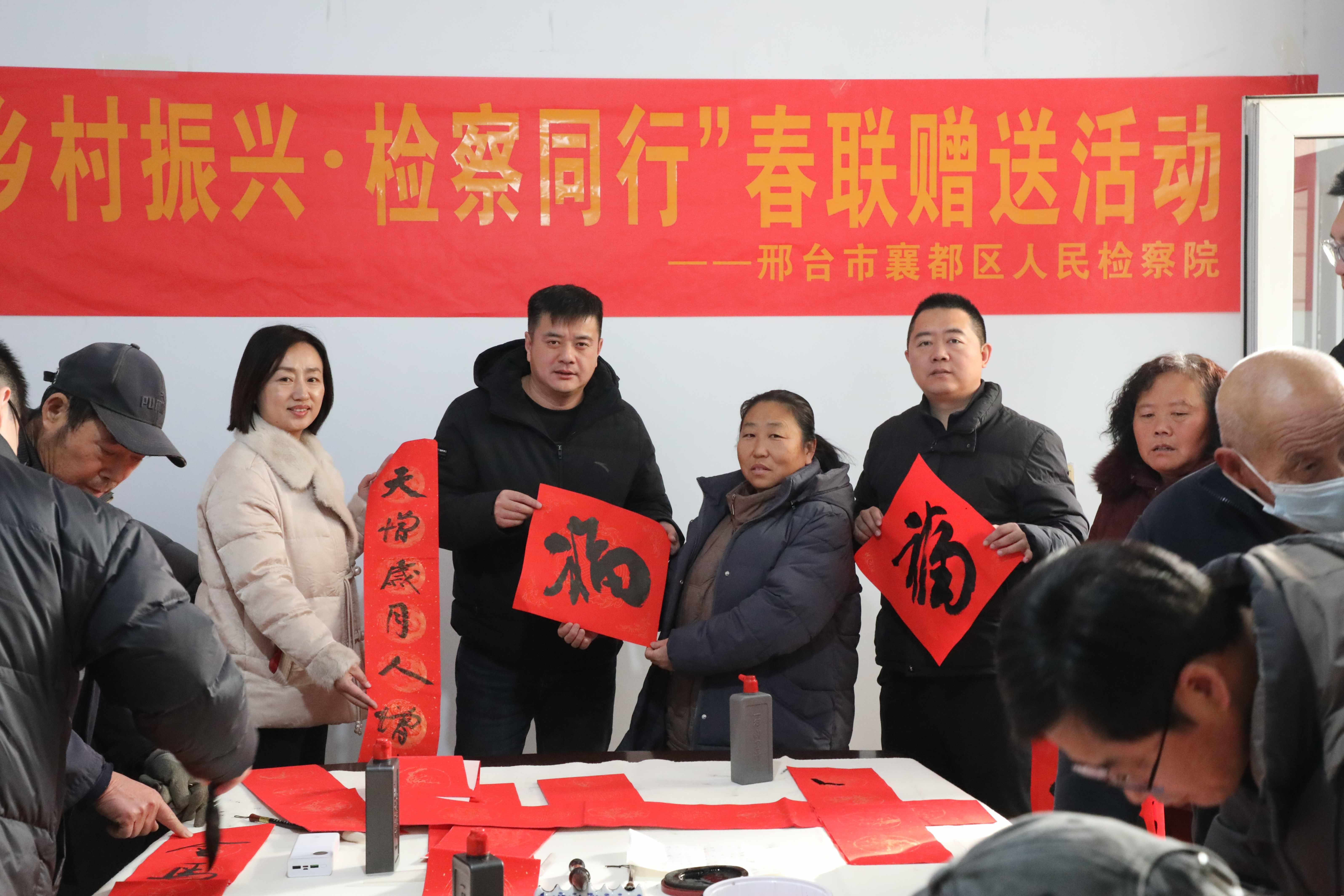 检察干警与群众拿着写好的对联和福字合影_副本.jpg